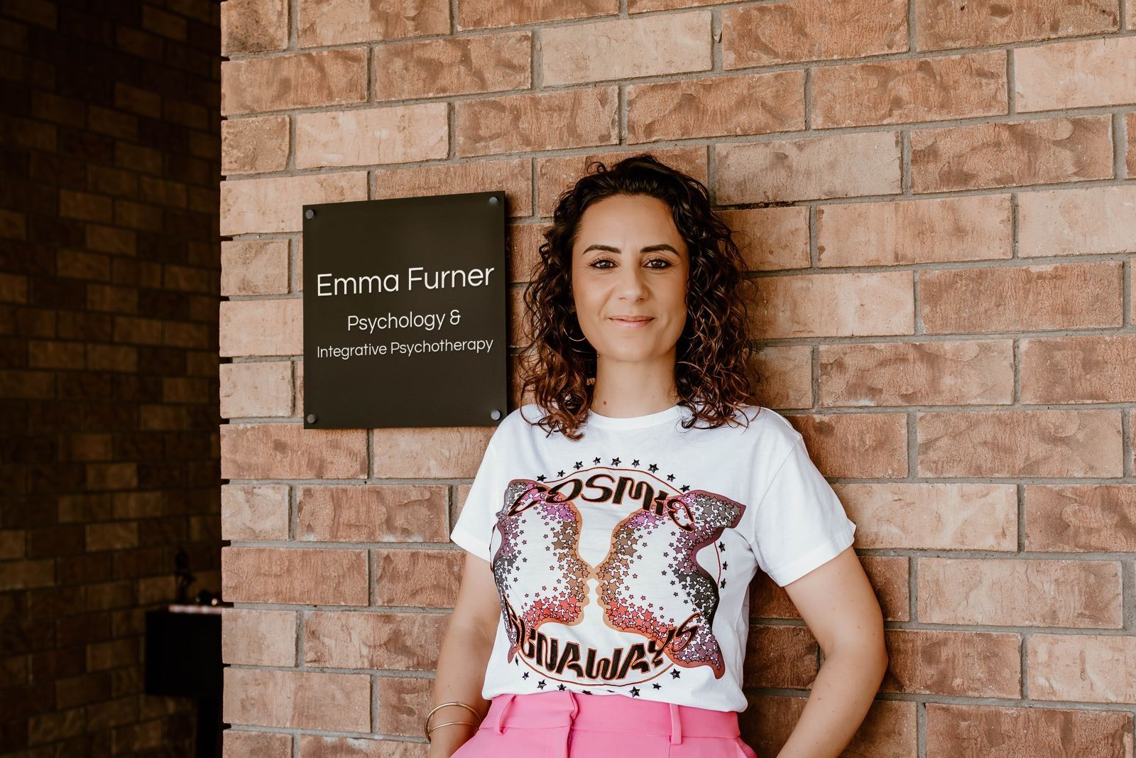 Emma smiling beside her practice sign