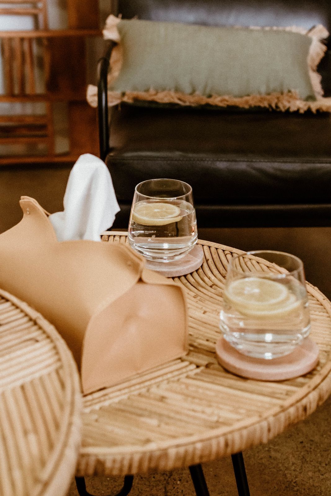 Glasses of water and tissues on a rattan table in the therapy room
