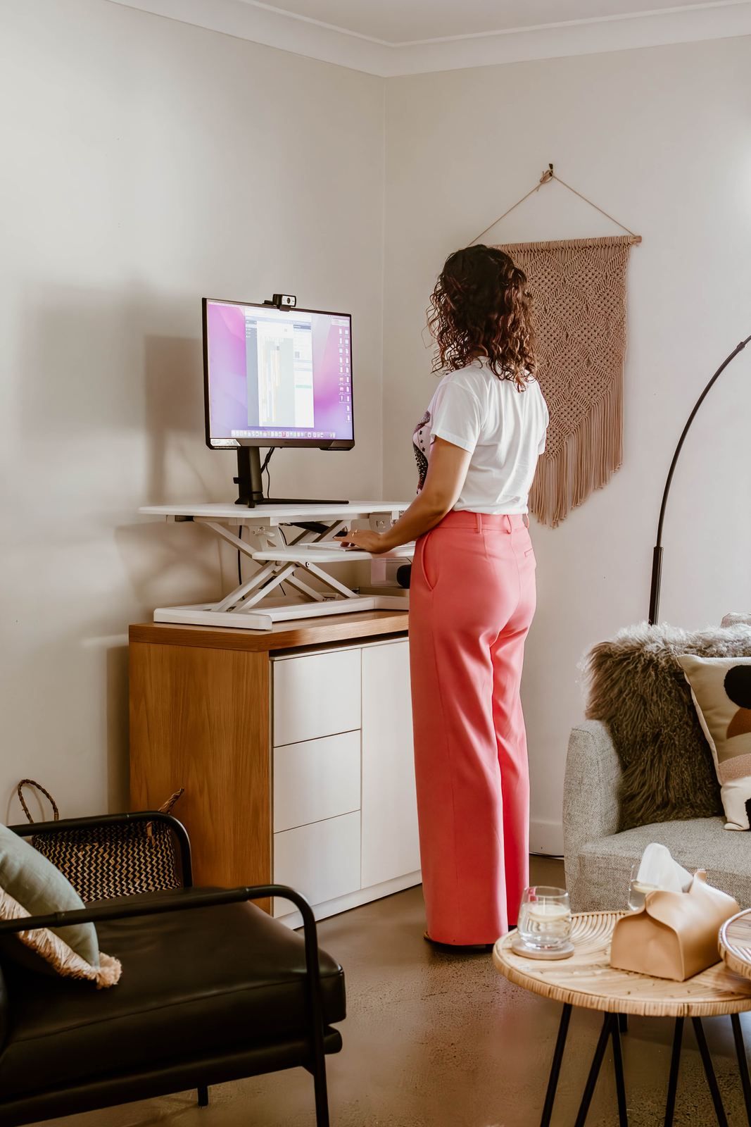 Emma working at a standing desk in the practice